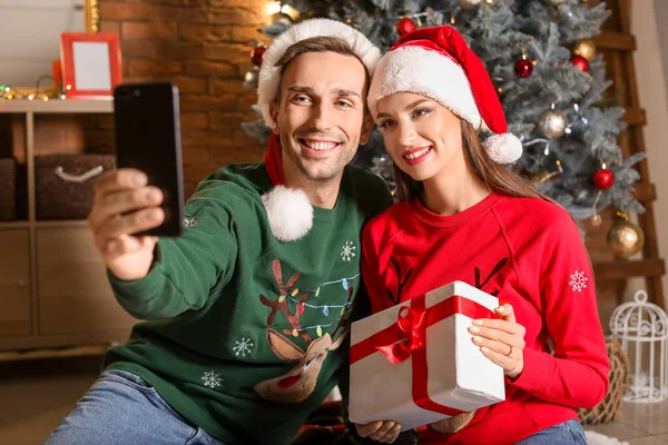 Pareja feliz tomando selfie en casa en Nochebuena — Foto de Stock