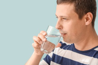 Arka planda taze su içen yakışıklı bir adamın portresi