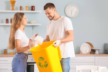 Evlerinde çöp konteynırı olan bir çift. Geri dönüşüm kavramı
