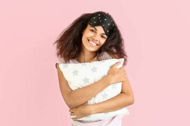 Renkli yastıklı ve uyku maskeli güzel bir Afro-Amerikalı kadın.