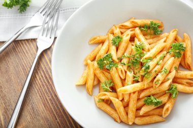 Ahşap masa üzerinde lezzetli makarna ile plaka