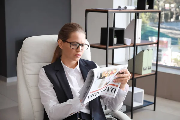 Joven empresaria leyendo periódico en la oficina — Foto de Stock