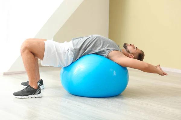Sporty young man training with fitball in gym — Stock Photo, Image