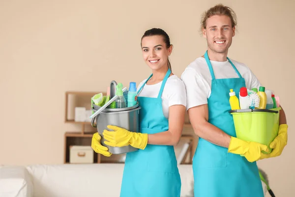 Equipe de zeladores com suprimentos de limpeza no quarto — Fotografia de Stock