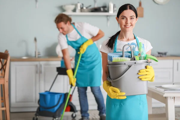 Női gondnok tisztítószerekkel a konyhában — Stock Fotó