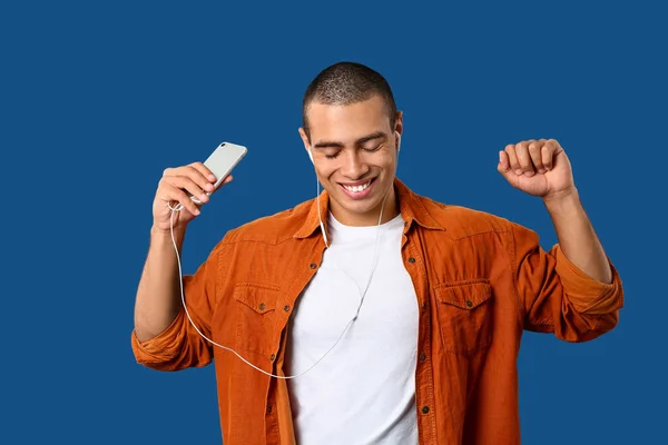 Retrato de un joven guapo escuchando música sobre fondo de color —  Fotos de Stock