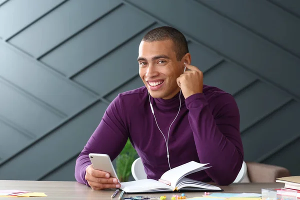 Portrait of handsome young man listening to music at home — Stock Photo, Image