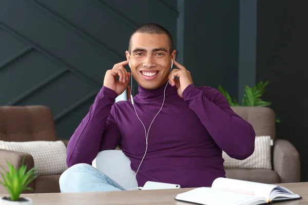 Portrait of handsome young man listening to music at home — Stock Photo, Image