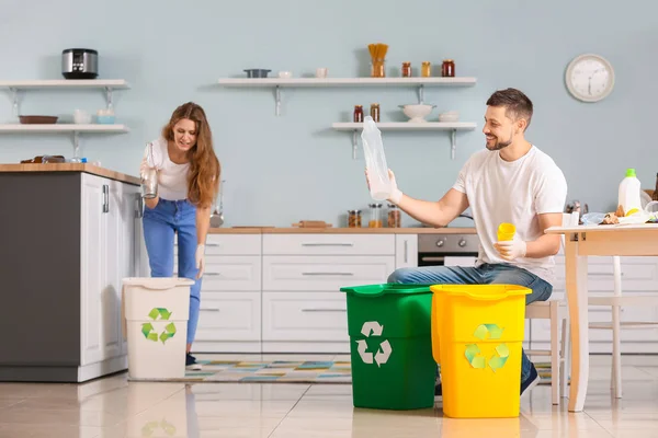 Couple sorting garbage at home. Concept of recycling