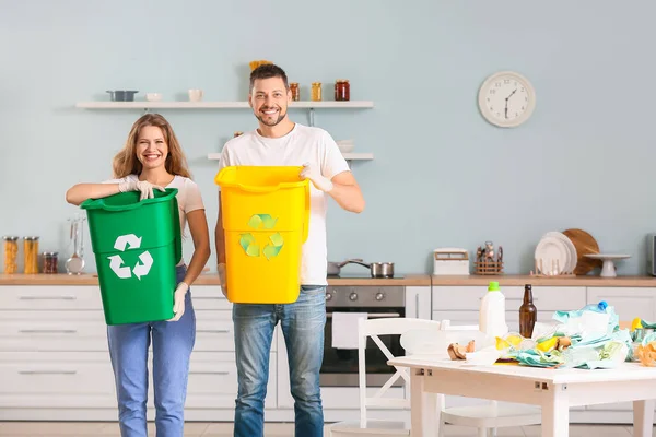 Couple with containers for garbage at home. Concept of recycling — Stock Photo, Image