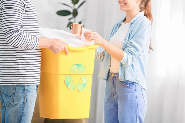 Pareja con contenedor para basura en casa. Concepto de reciclaje — Foto de Stock