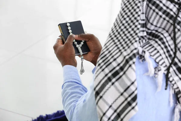 African-American Muslim man praying indoors, closeup