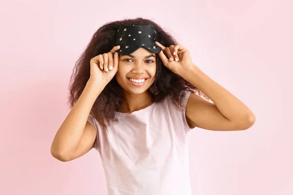 Bella donna afro-americana con maschera del sonno su sfondo di colore — Foto Stock