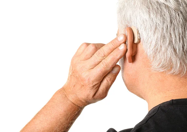 Mature man with hearing aid on white background — Stock Photo, Image
