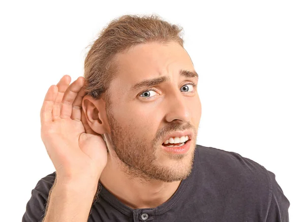Молодой человек с проблемами со слухом на белом фоне — стоковое фото