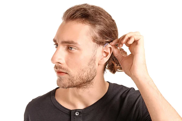 Jeune homme avec prothèse auditive sur fond blanc — Photo