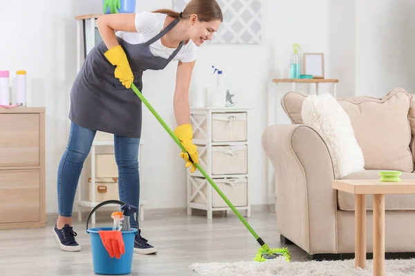 Female janitor mopping floor in room — Stock Photo, Image