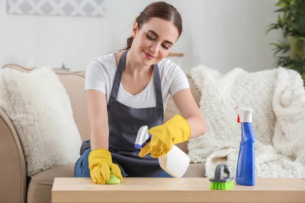 Hausmeisterin putzt Tisch im Zimmer — Stockfoto