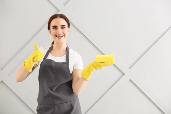 Hausmeisterin zeigt Daumen-hoch-Geste auf grauem Hintergrund — Stockfoto