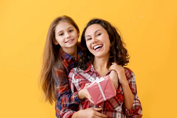 Kleines Mädchen grüßt ihre Mutter auf farbigem Hintergrund — Stockfoto