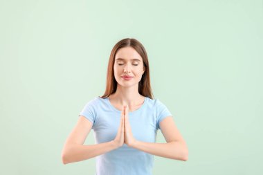 Güzel bir kadın hafif arka planda meditasyon yapıyor.