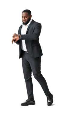 Beyaz arka planda kol saatine bakan şık Afro-Amerikan bir adam.