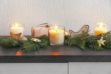 Güzel yanan mumlar, Noel dekorasyonu ve masa üstünde köknar dalları.