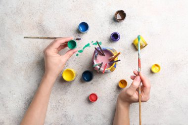 Masada boyaları olan bir kadın sanatçı.