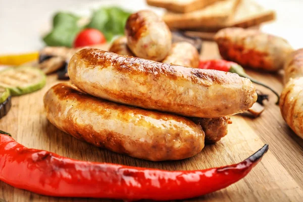 Tasty grilled sausages wooden board, closeup — Stock Photo, Image