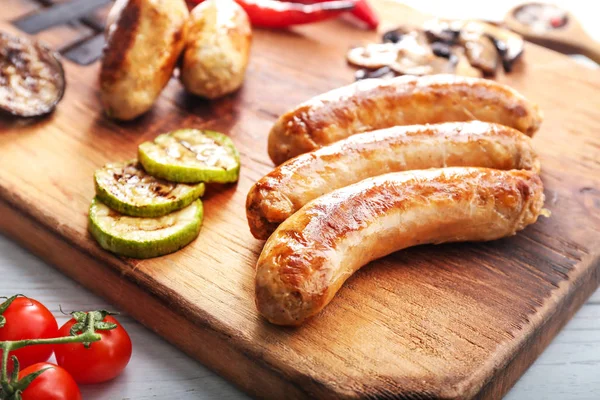 Tasty grilled sausages wooden board, closeup — Stock Photo, Image