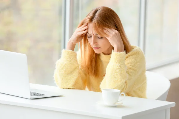 Mature woman suffering from head ache in office — Stock Photo, Image