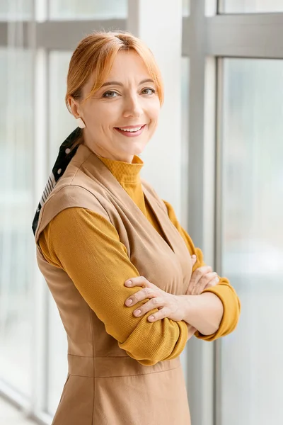 Portrait of mature woman near window in office — Stock Photo, Image