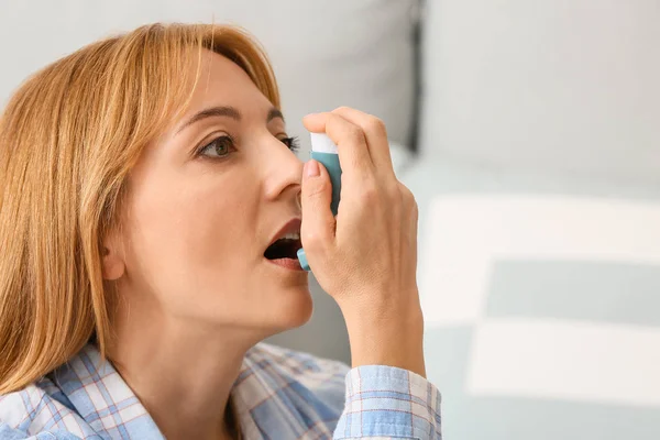 Schöne reife Frau mit Asthma-Inhalator zu Hause — Stockfoto