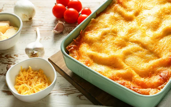 Sabrosa lasaña al horno con ingredientes en la mesa —  Fotos de Stock