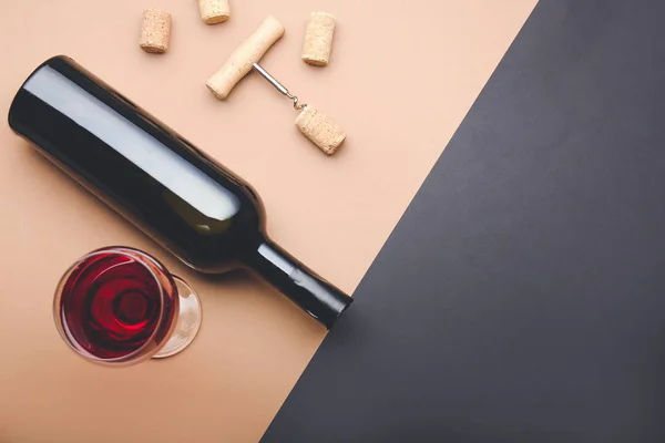 Bottle and glass of wine with corks and opener on color background — Stock Photo, Image