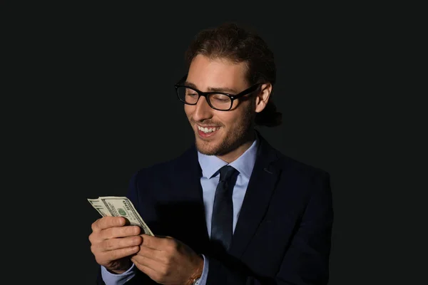 Retrato de hombre de negocios guapo con dinero sobre fondo oscuro — Foto de Stock