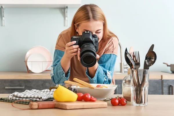 Genç fotoğrafçı mutfakta sebze salatası fotoğrafı çekiyor. — Stok fotoğraf