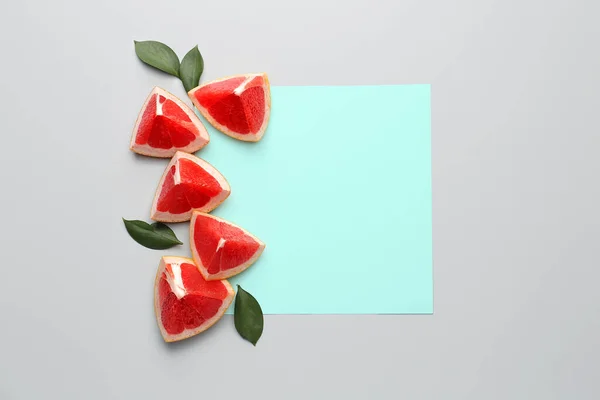 Fresh cut grapefruit and blank card on light background