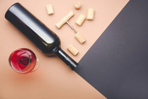 Bottle and glass of wine with corks and opener on color background — Stock Photo, Image