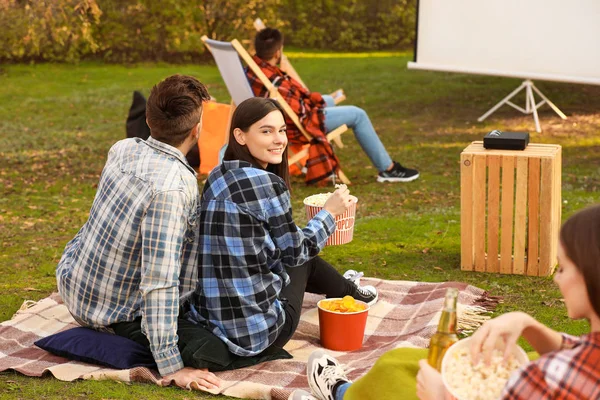 Young couple watching movie in outdoor cinema — Stock Photo, Image