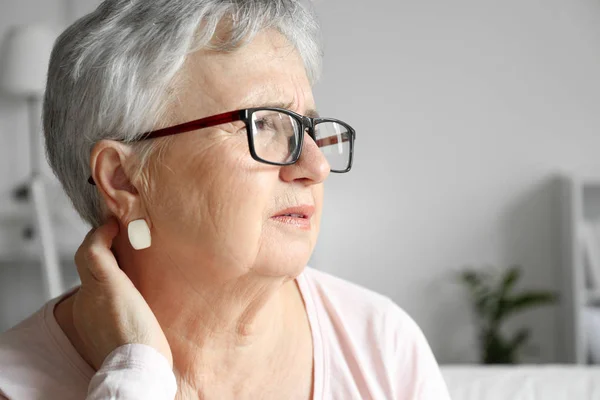 Mujer mayor que sufre de dolor de cuello en casa — Foto de Stock