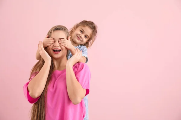 Lycklig kvinna och hennes lilla dotter på färg bakgrund — Stockfoto