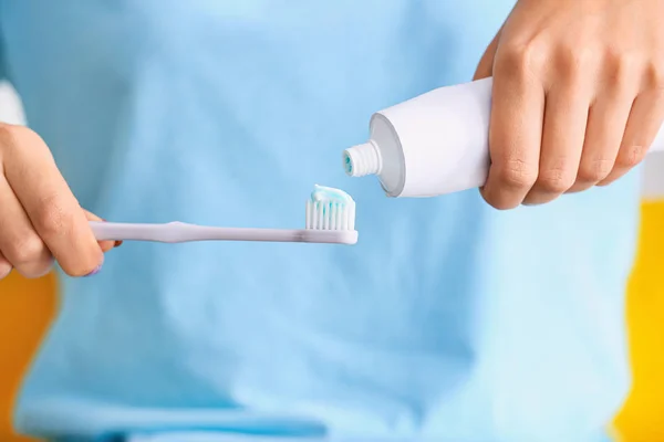 Woman squeezing tooth paste on brush, closeup — Stock Photo, Image
