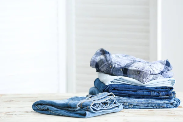 Pilha de roupas limpas na mesa no quarto — Fotografia de Stock