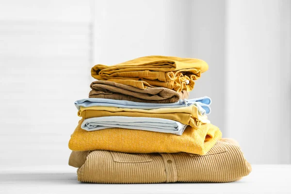Stack of clean clothes on table in room — Stock Photo, Image