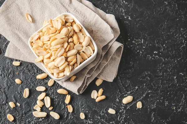 Bowl with peanuts on dark background — Stock Photo, Image