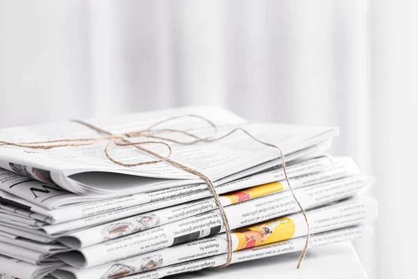 Stack of newspapers on table in room — ストック写真