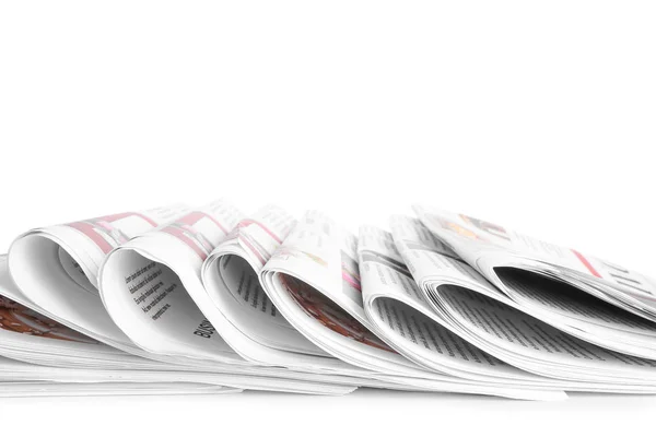 Muitos jornais na mesa contra fundo branco — Fotografia de Stock