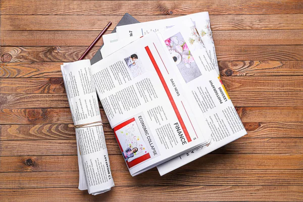 Many newspapers on wooden background — Stock Photo, Image