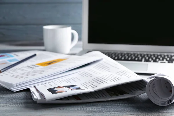 Εφημερίδες, laptop και φλιτζάνι καφέ στο τραπέζι — Φωτογραφία Αρχείου